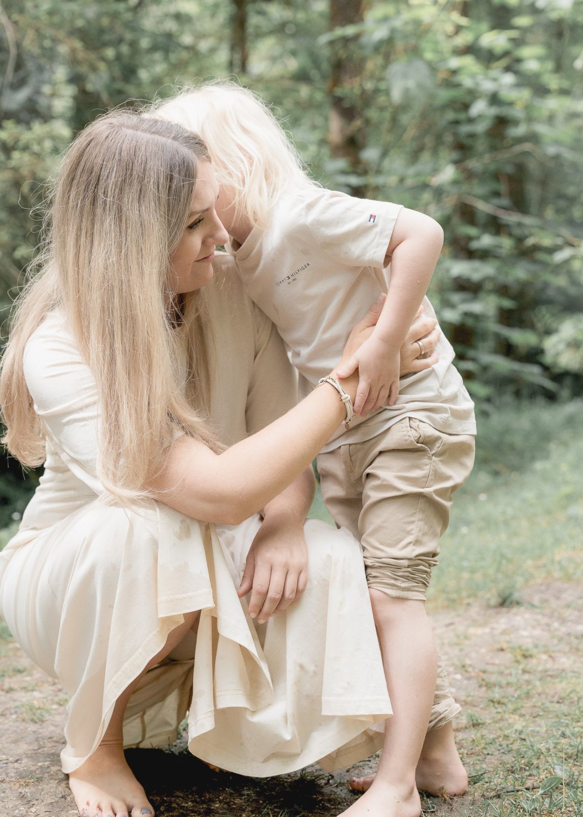 Mama umarmt ihren Sohn im Wald